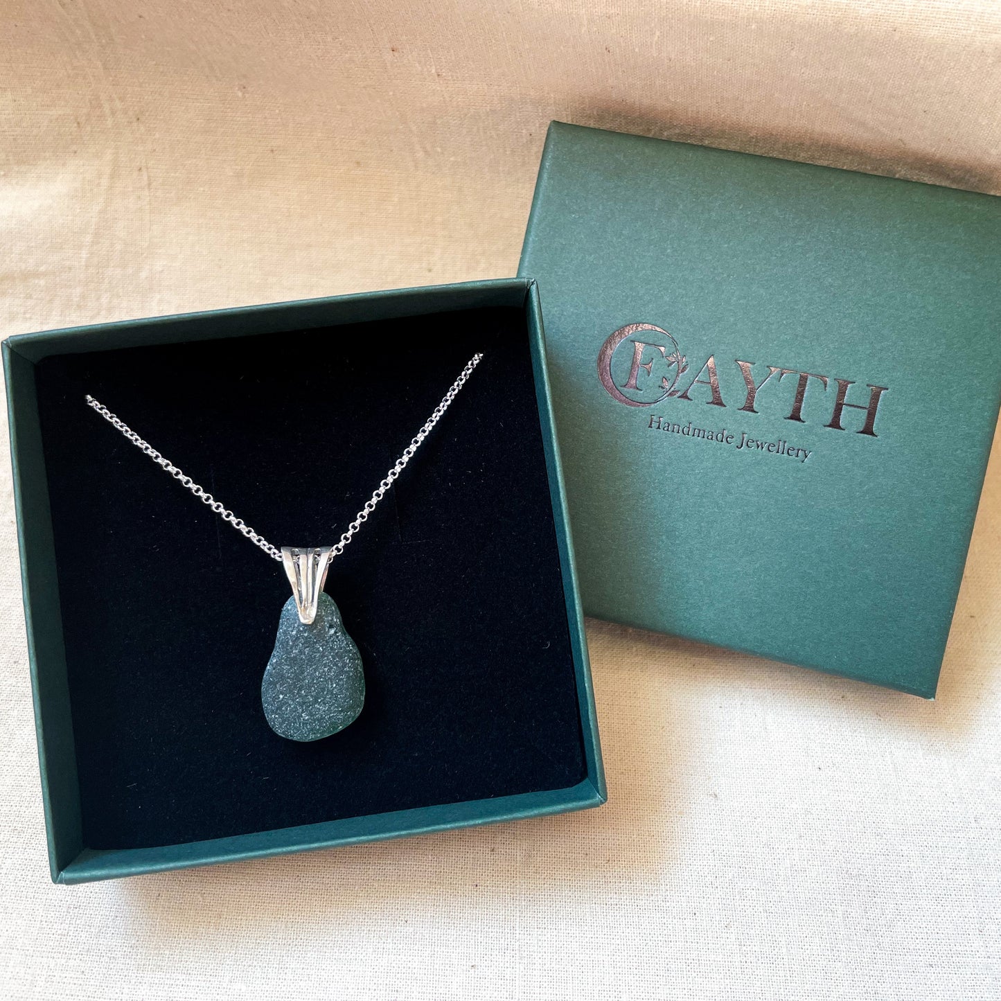 Green sea glass necklace on a silver belcher chain in a dark green gift box with black foam insert