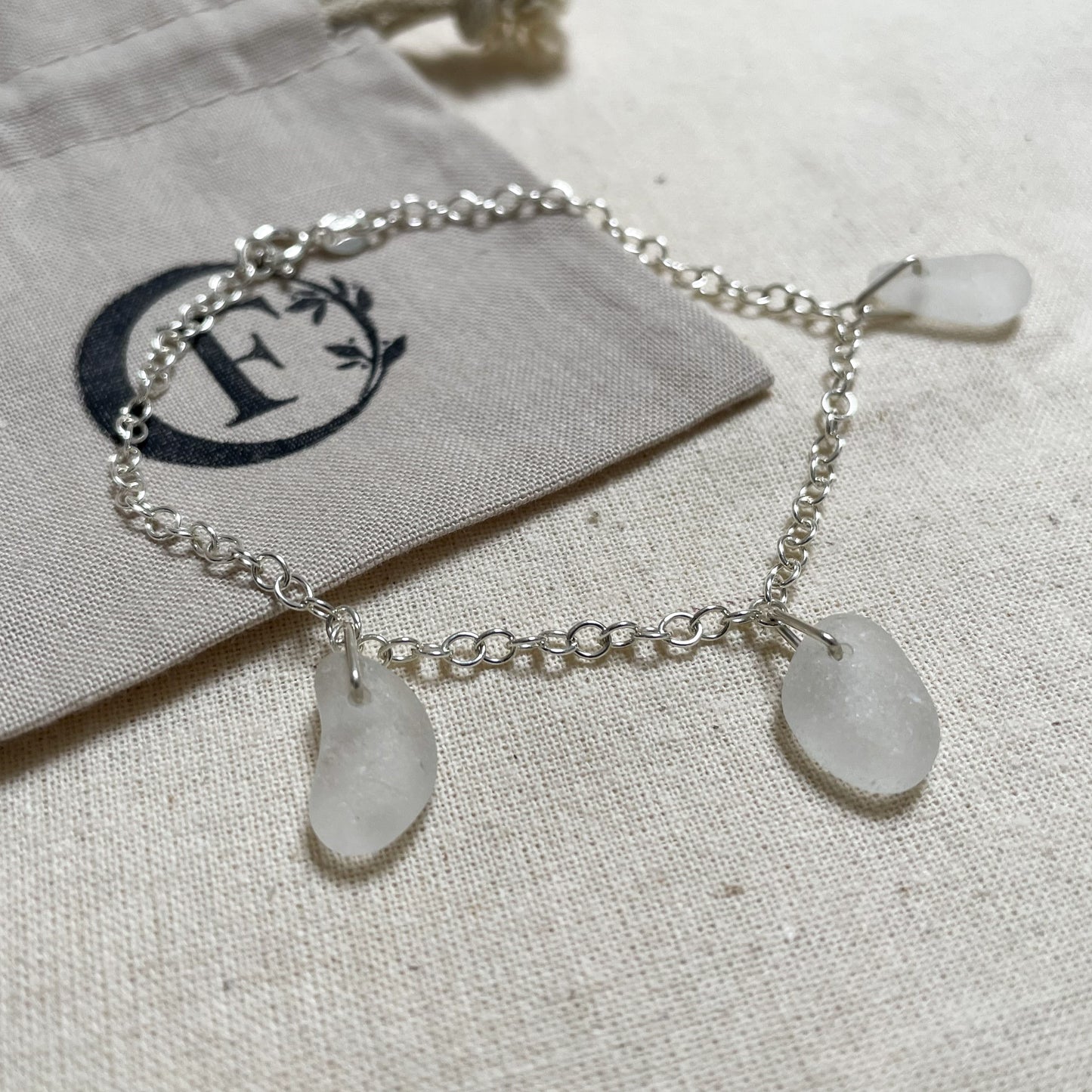 Sterling silver cable chain bracelet with three pieces of white sea glass