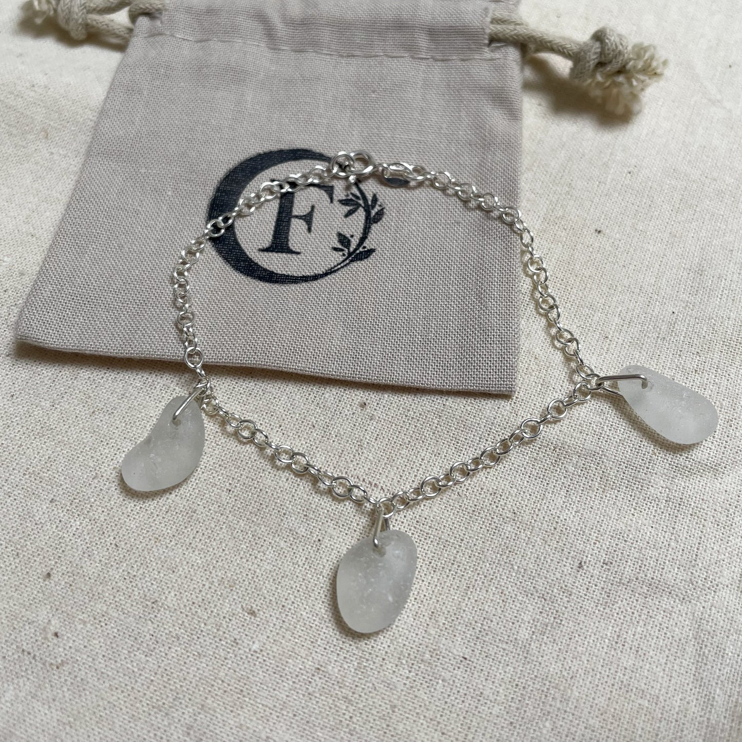 Sterling silver cable chain bracelet with three pieces of white sea glass