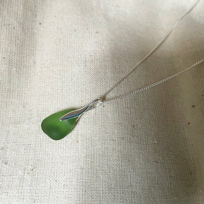 Green sea glass necklace on beige background