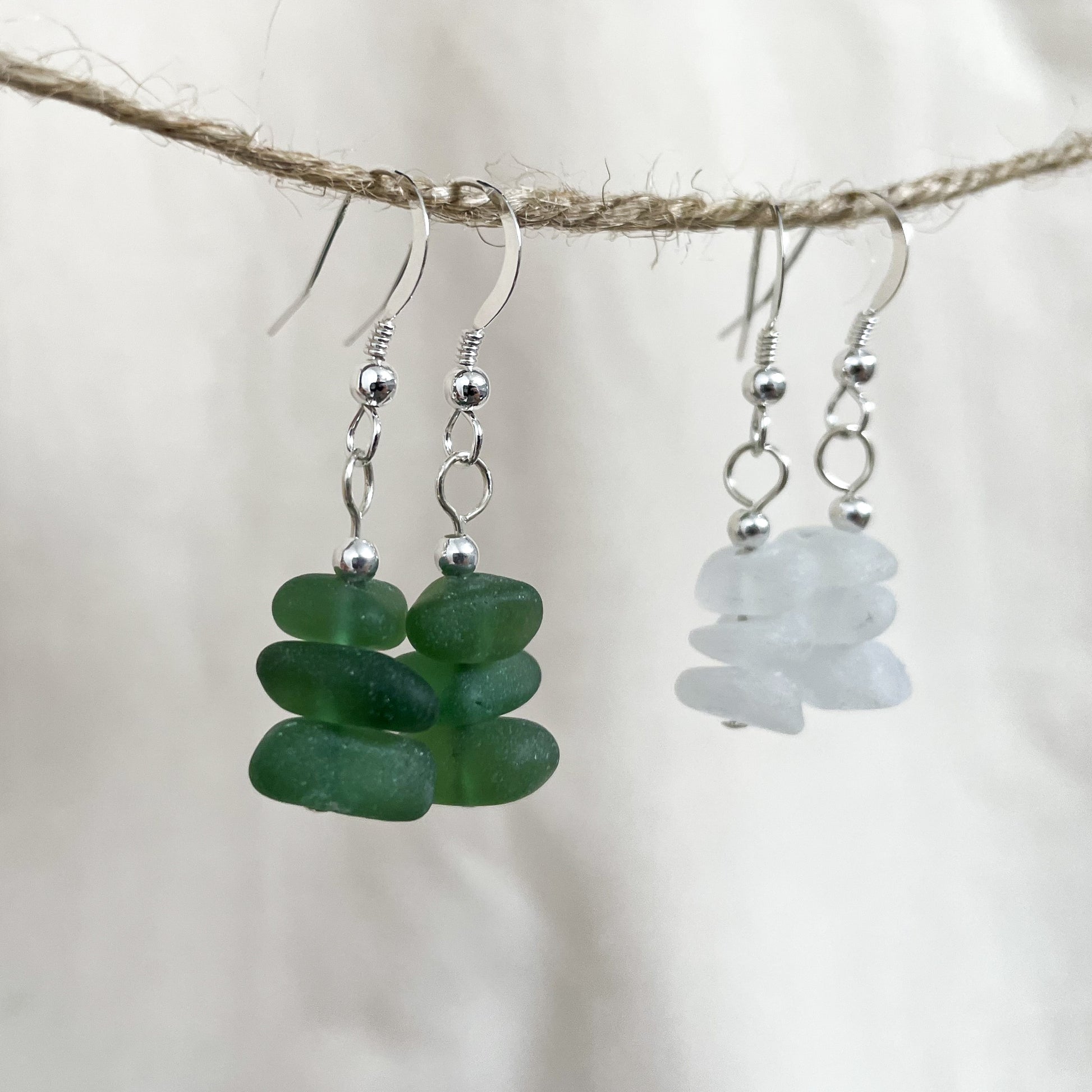 green sea glass dangle earring made up of three pieces of green sea glass and one silver bead