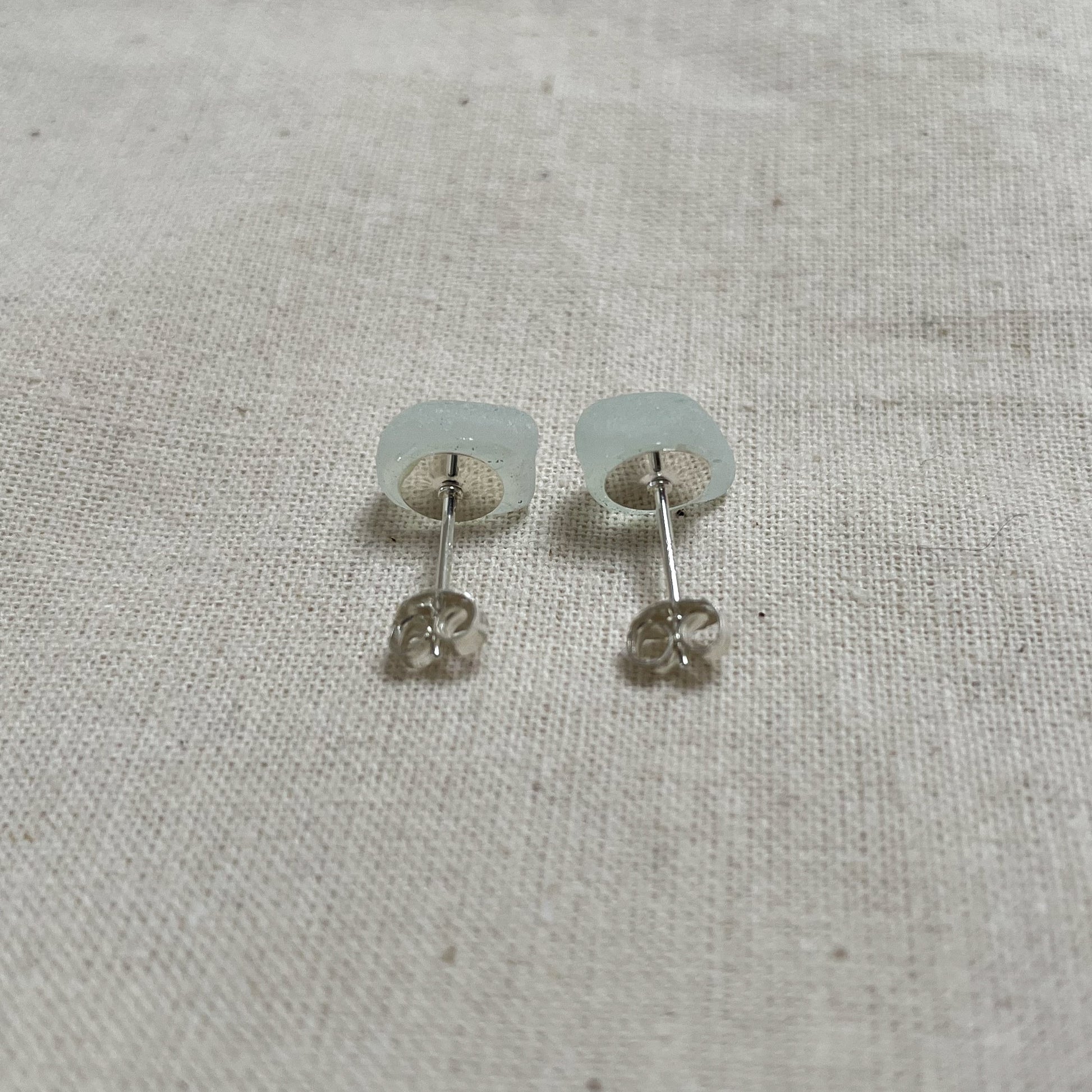 light blue sea glass stud earrings from behind, showing the sterling silver ear post and butterfly back